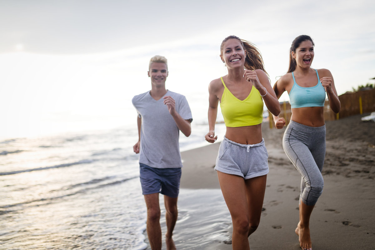 Group of sport people jogging on the beach
